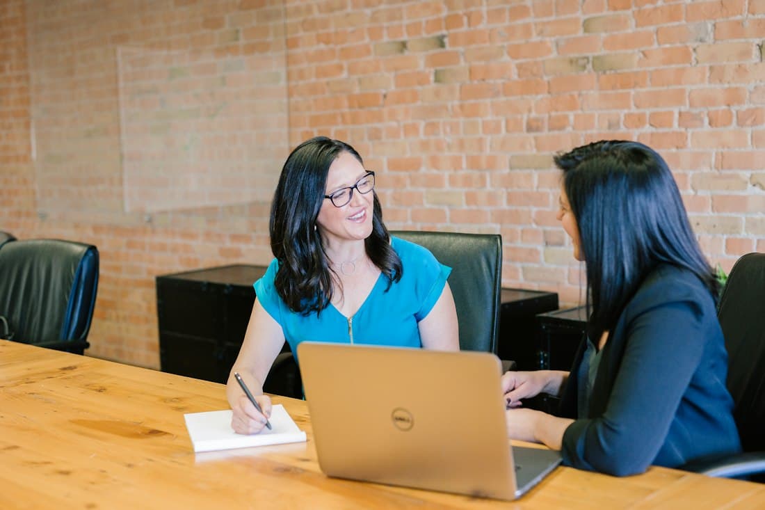 Two women talking over a laptop