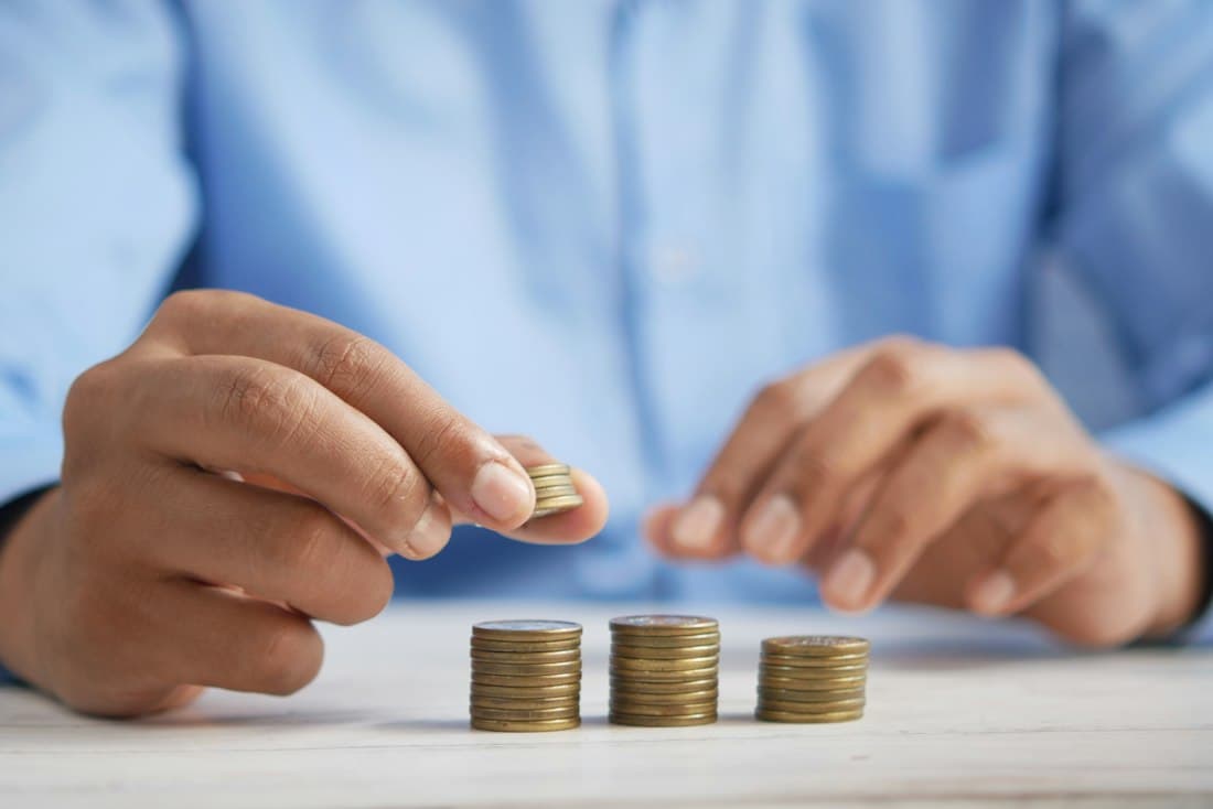 Hands stacking coins into piles